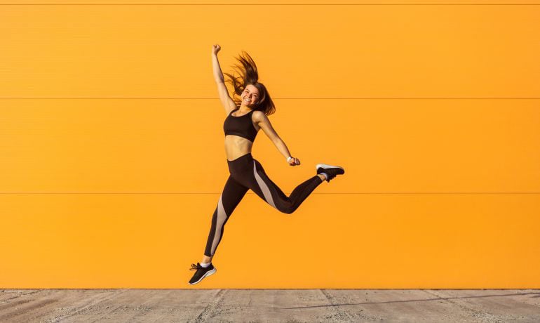 why should I start being healthier like this woman jumping infront of yellow wall