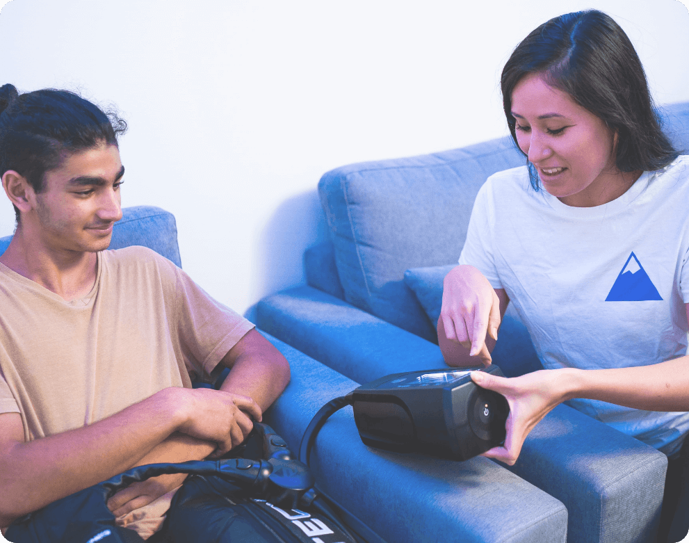 woman showing man how to control the normatec boots