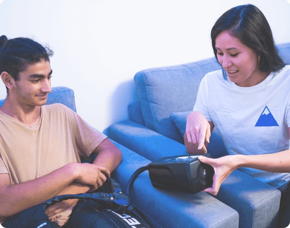 woman teaching man about normatec boots